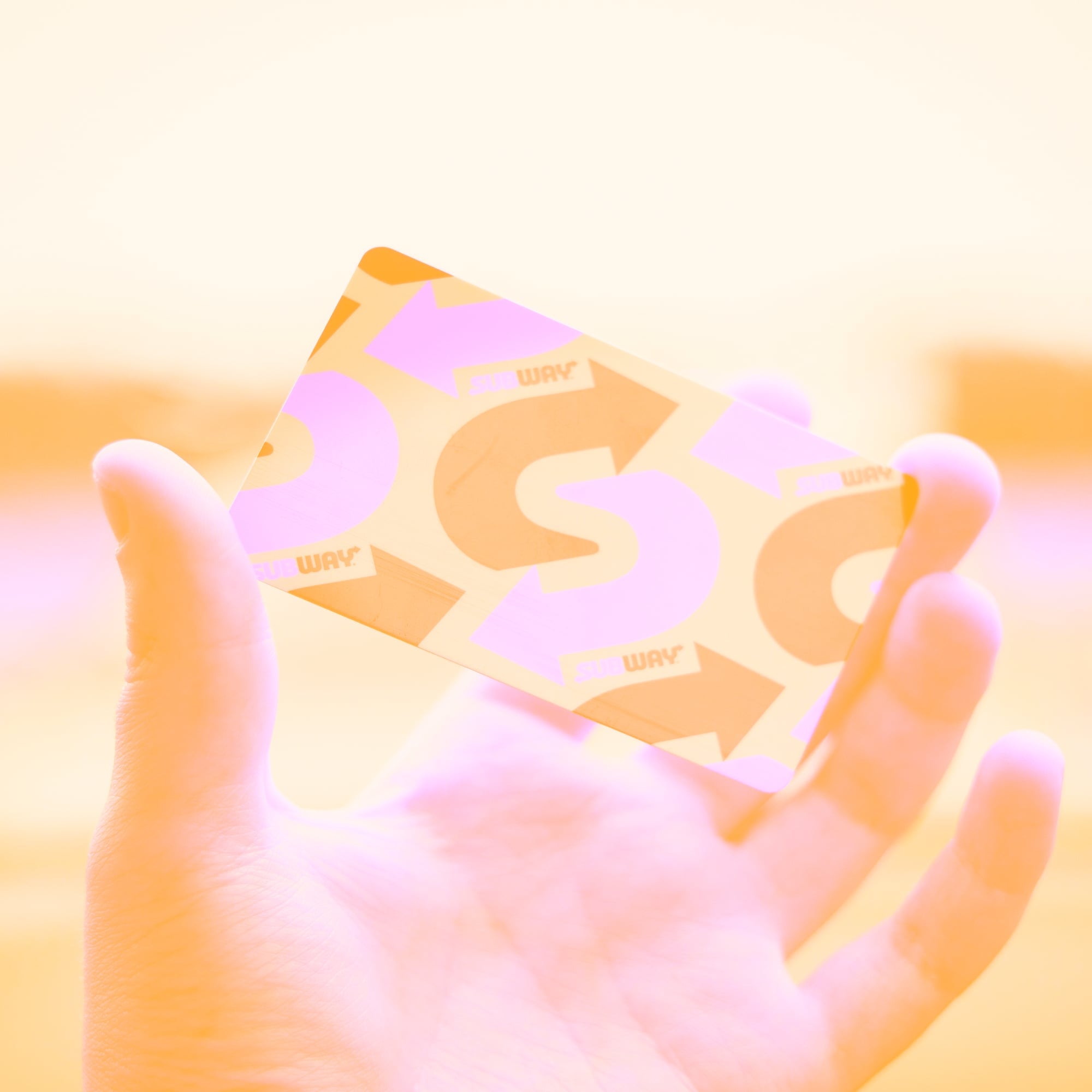 hand holding branded business card with arrow design golden toned