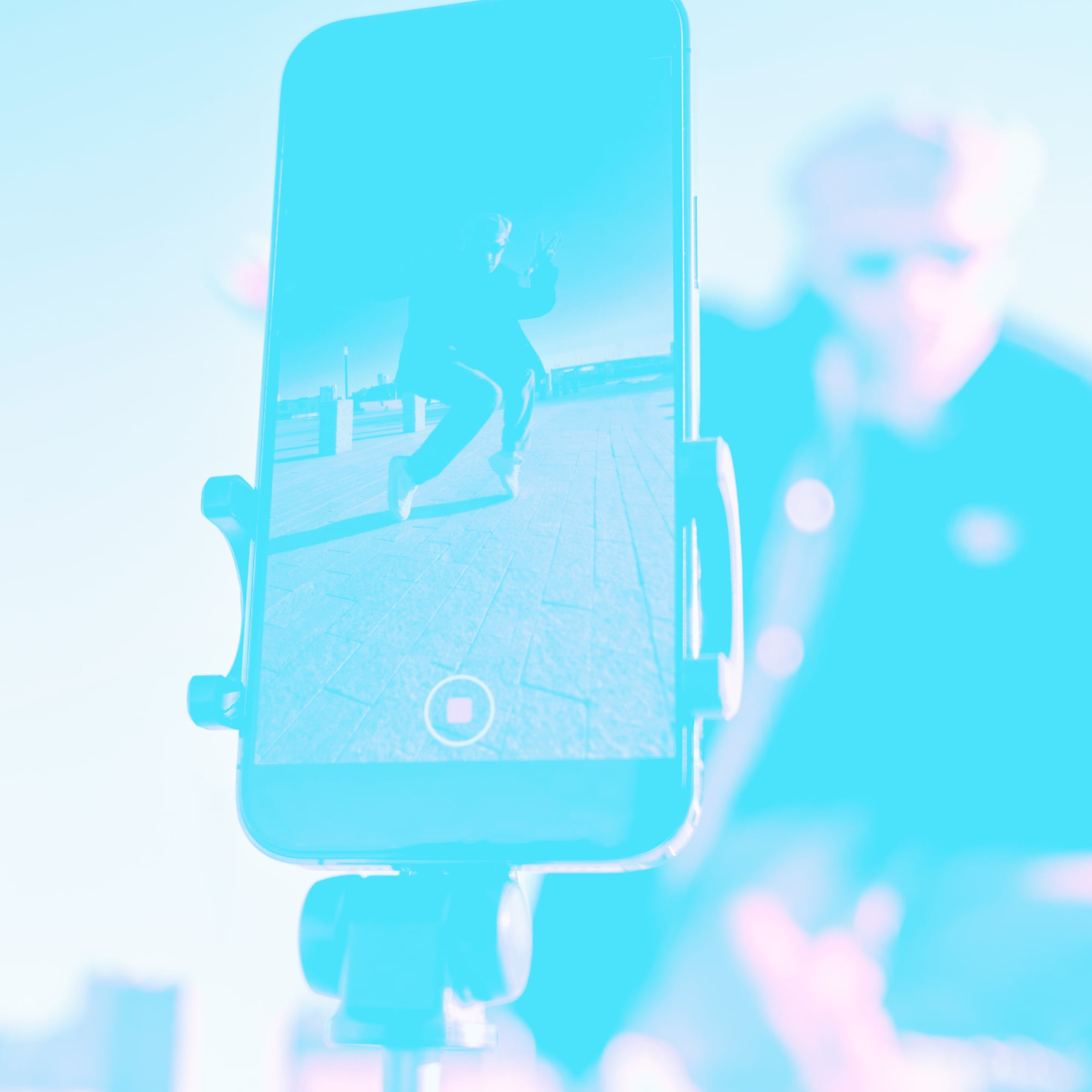 smartphone on tripod recording person dancing outdoors teal toned