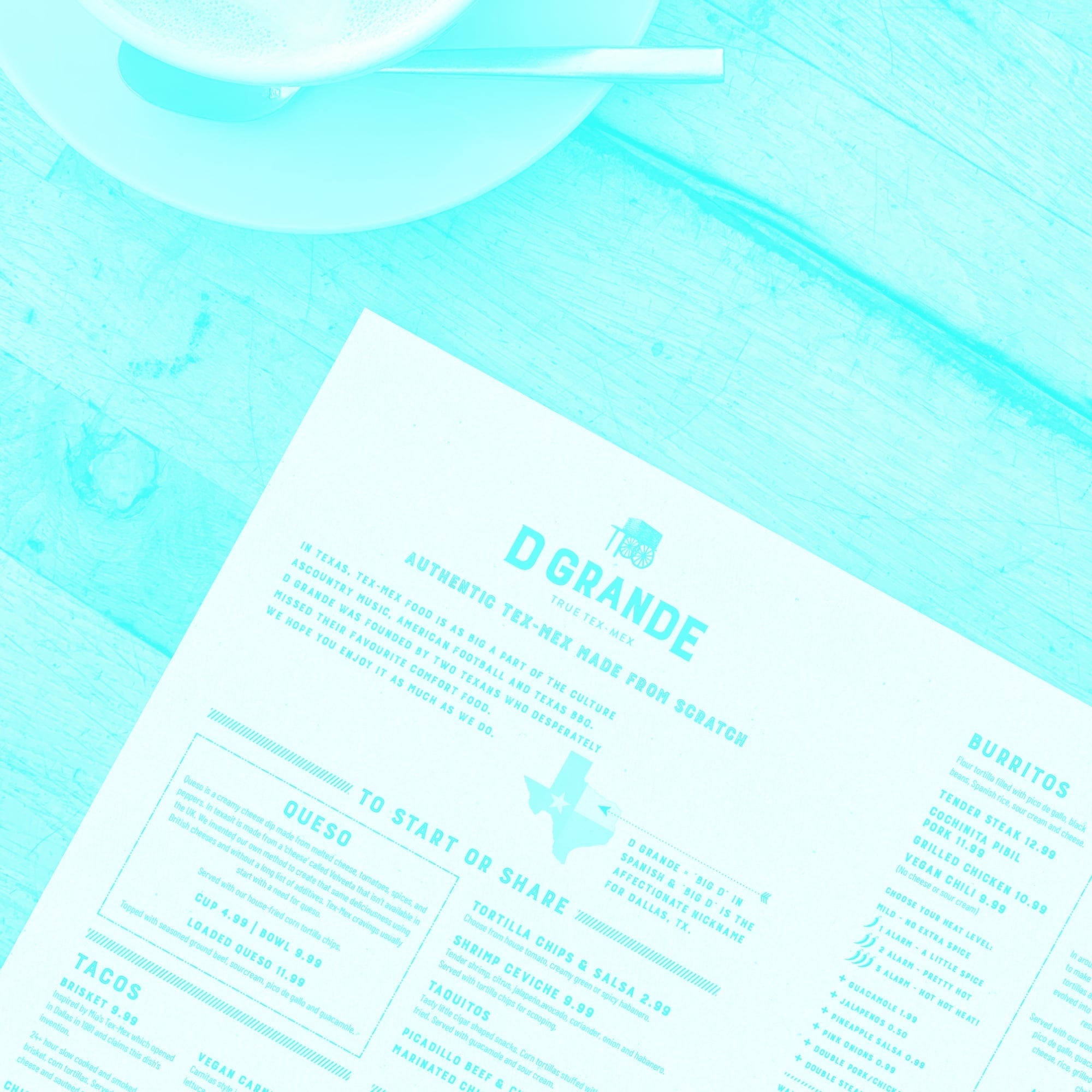 d grande restaurant menu on wooden table with drink teal toned