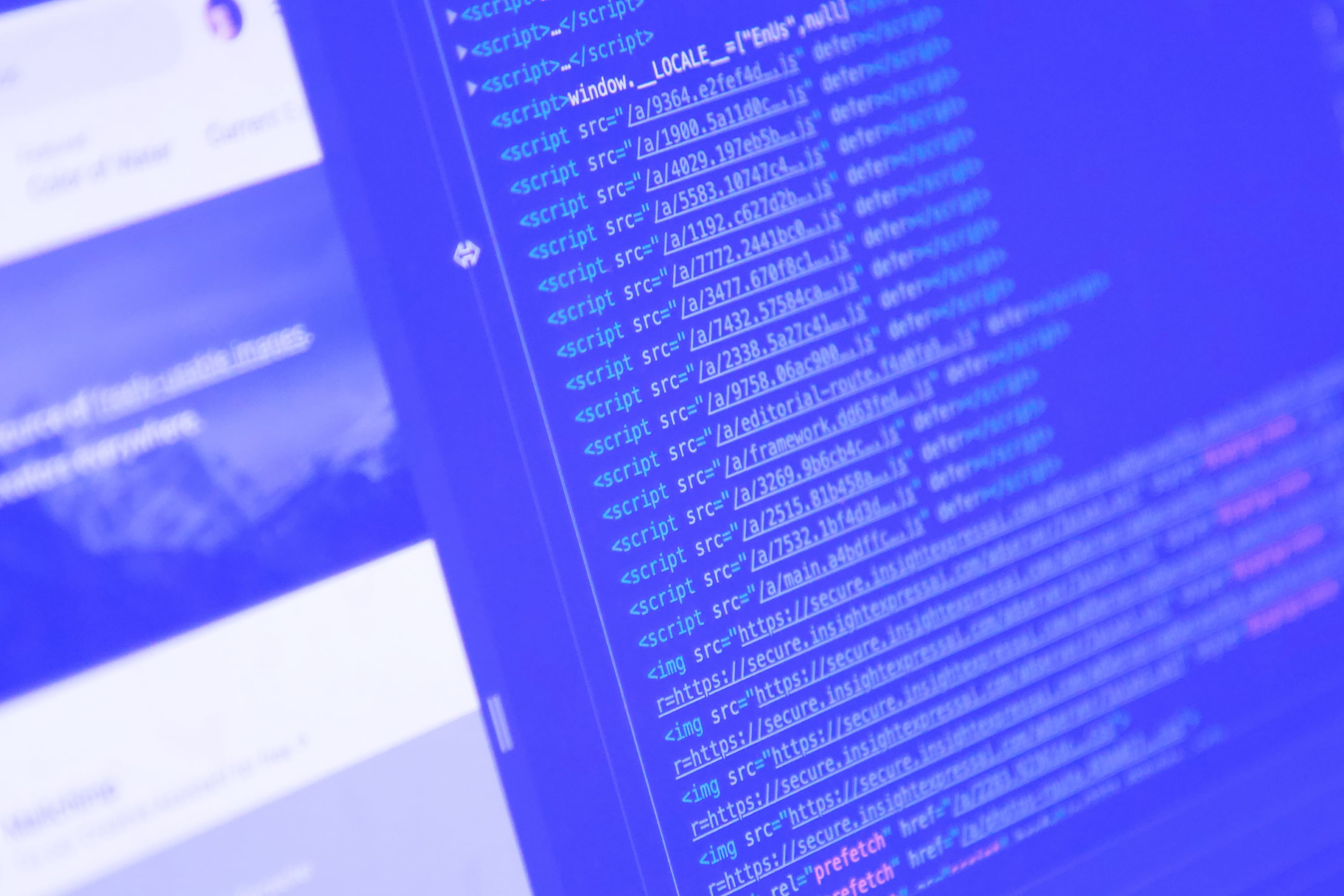 html javascript source code on monitor screen with website preview blue toned