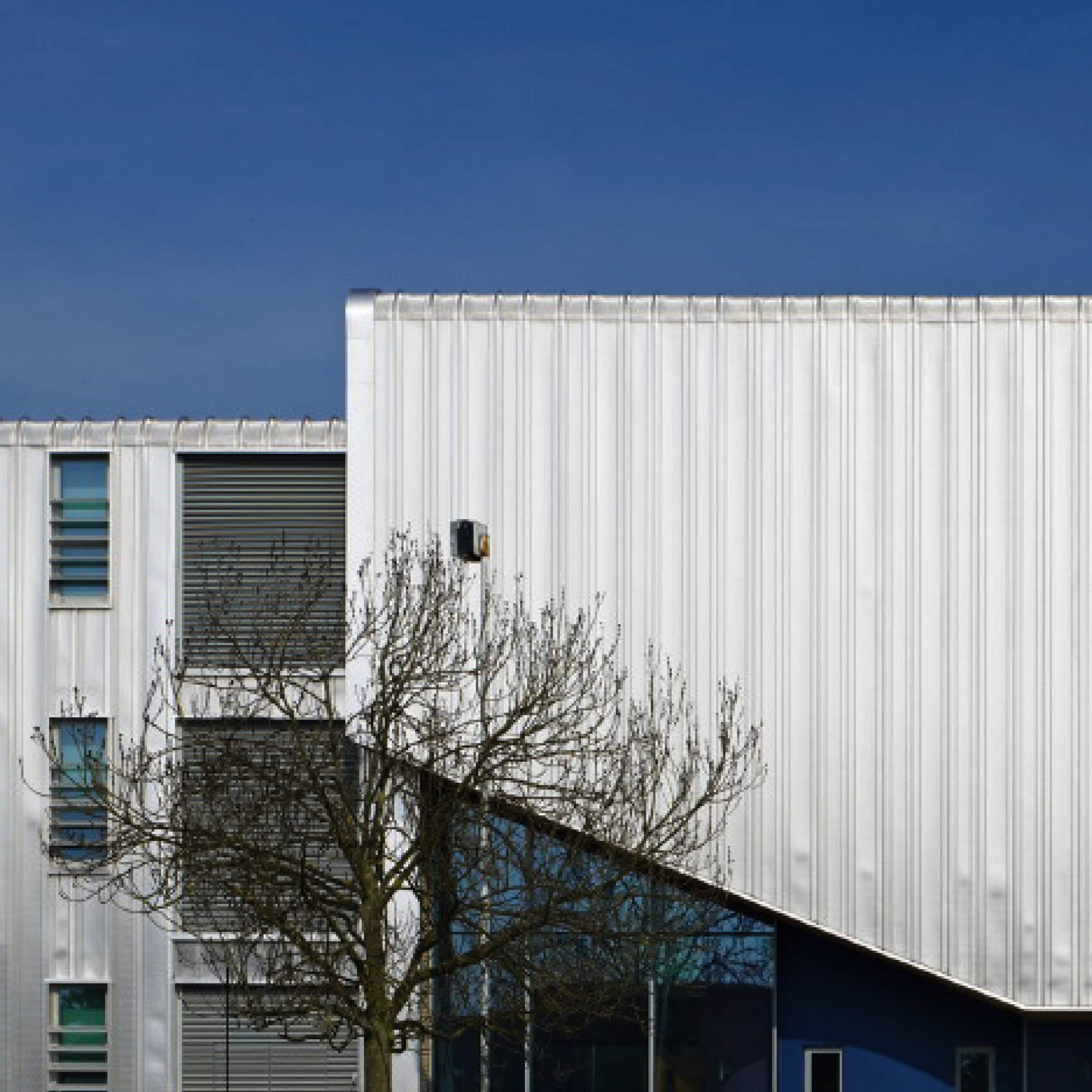 Modern building exterior with white cladding and glazed entrance