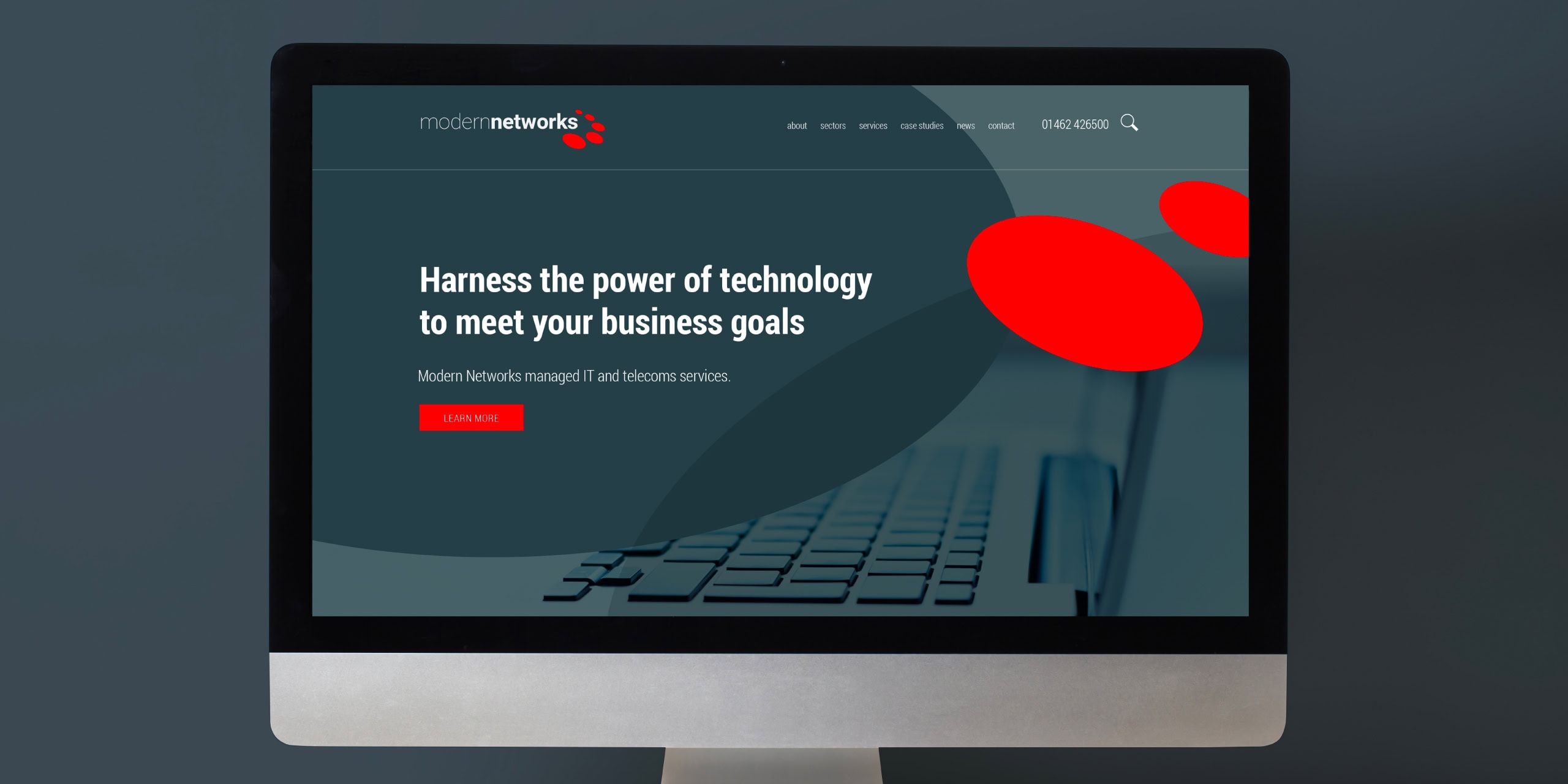 Modern Networks website homepage shown on a desktop monitor with headline and red accent shape