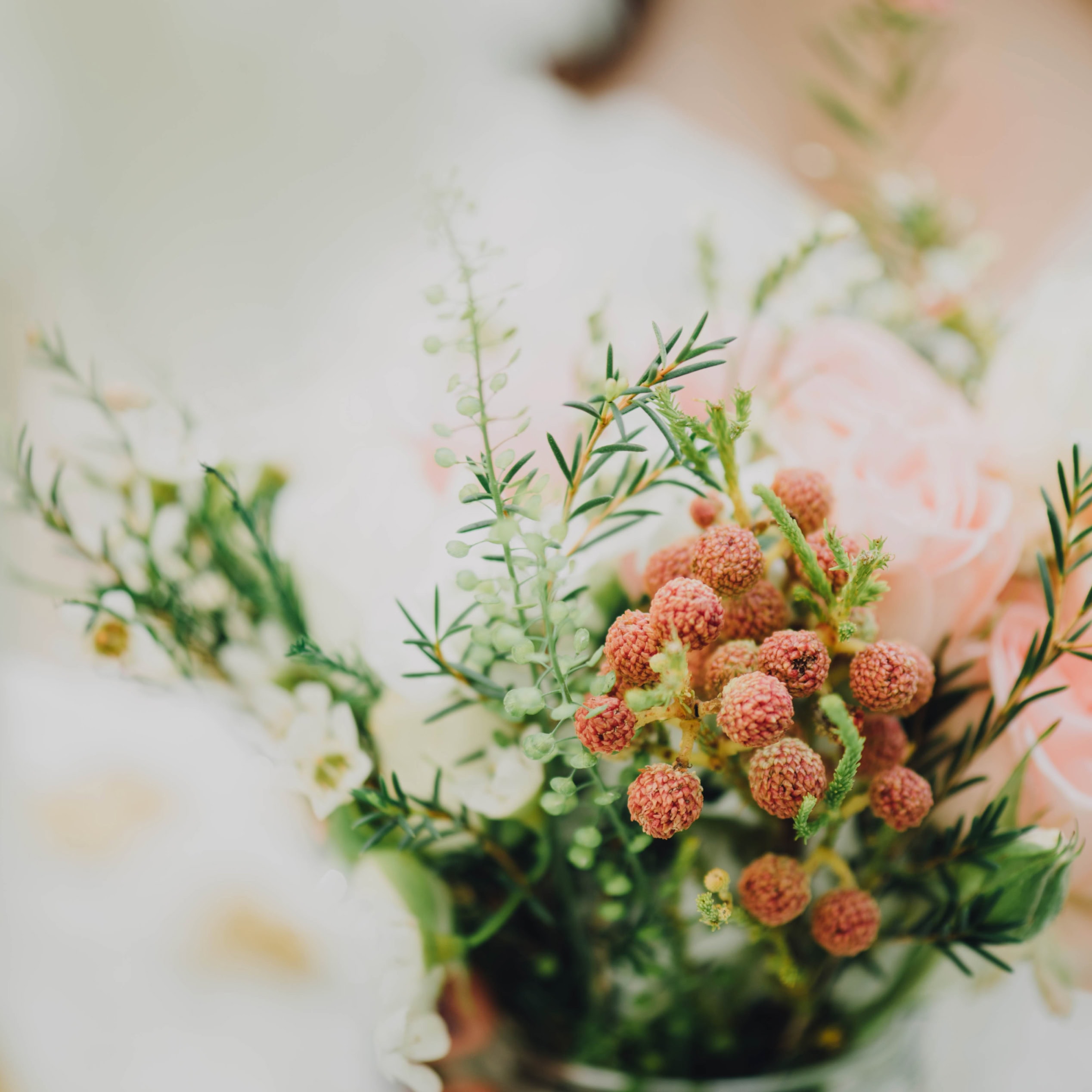 Close-up of a bridal bouquet with berries, roses and greenery