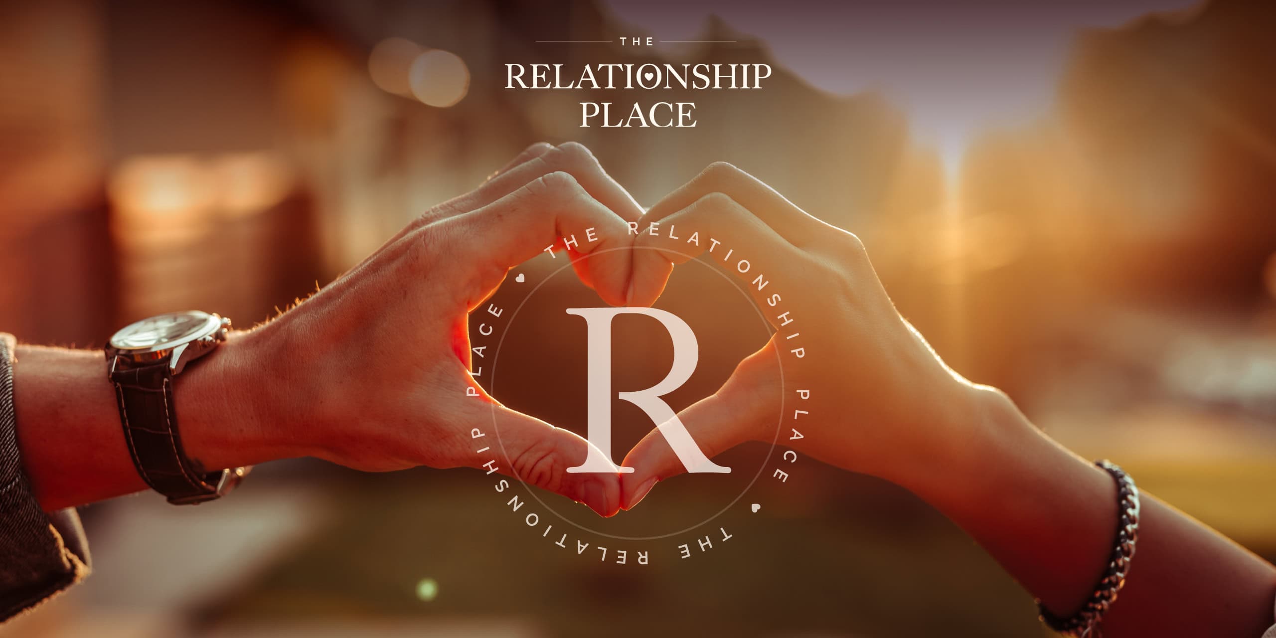 The Relationship logo overlaying an image of hands making a heart shape