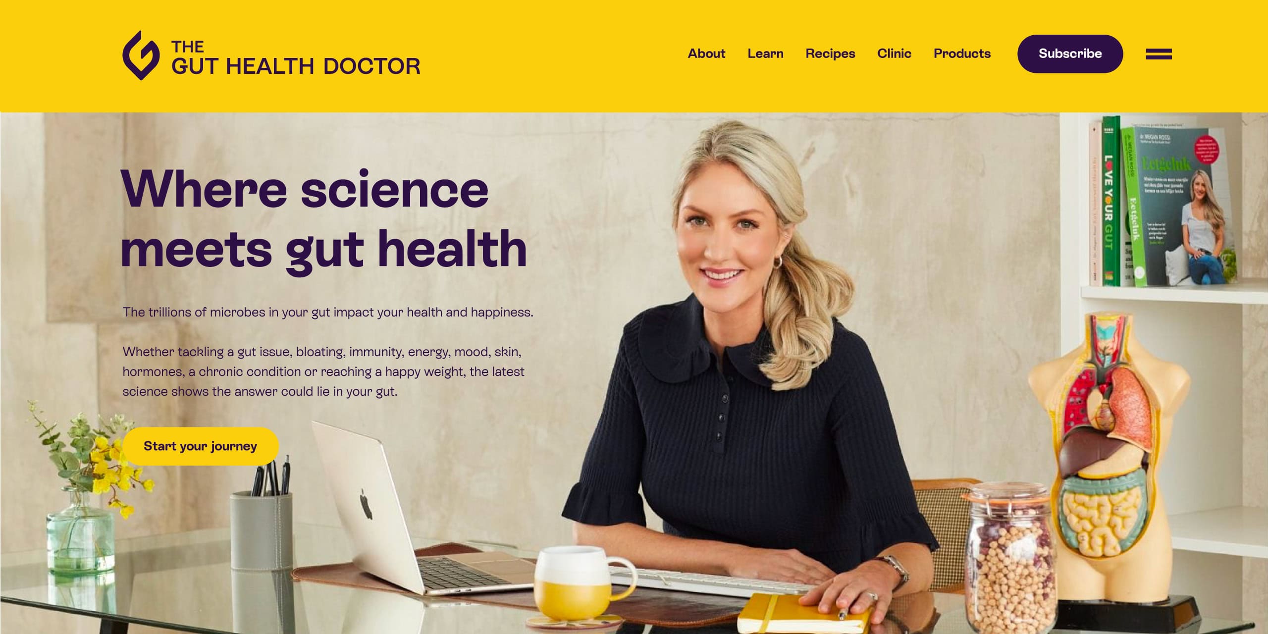Homepage hero showing Dr Megan Rossi at a desk, with gut model and books on a shelf